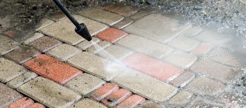 Pinnacle Pressure Cleaning and Sealing, LLC cleaning driveway pavers with high-pressure washing in Naples, FL.